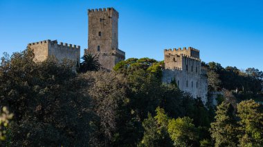 Erice, Sicily, Italy. Glimpse of Venus Castle with trees and blue sky