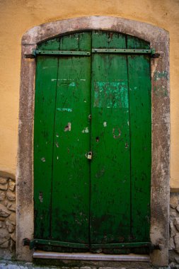 Antika yeşil ahşap kapı sürgüyle kapatılmış.