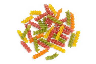 Çiğ Fusilli renkli makarna, beyaz arka planda izole edilmiş, kırpma yolu ve tam derinlikte. Üst Manzara. Düz yatıyordu