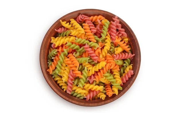 Raw Fusilli colored pasta in ceramic bowl isolated on white background with clipping path and full depth of field. Top view. Flat lay — Fotografia de Stock