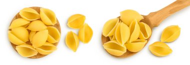 Kaşık içinde pişmemiş kurutulmamış conchiglie. Çiğ kabuklu makarna, beyaz deniz tabanında izole edilmiş, geniş bir alana yayılmış. Üst Manzara. Düz yatıyordu.