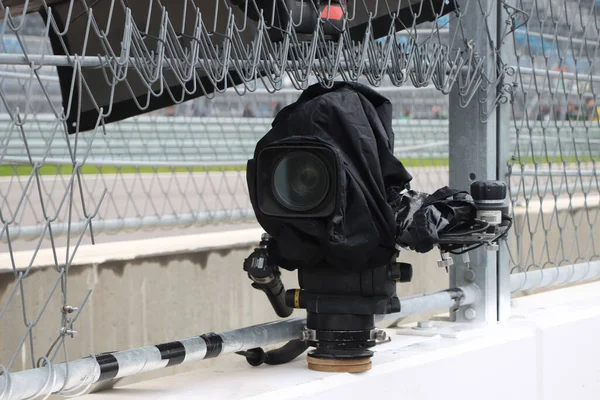 TV camera broadcasting live a race at motor racing track.