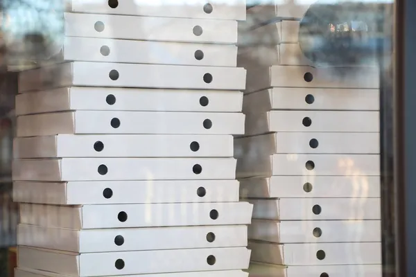 Pizza dağıtım servisinin vitrininde bir sürü beyaz kutuyu bulanıklaştırdı. Yumuşak odak.
