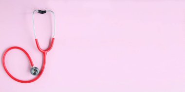 Pembe arka planda kırmızı stetoskobun üst görüntüsü. Tıp konsepti. Sancak Boyutu.