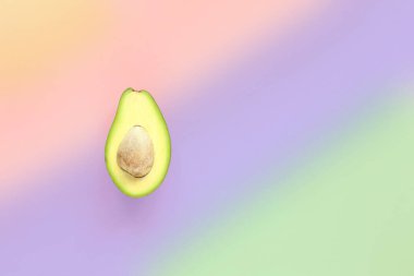 Avokadonun yarısı çok renkli arka planda. Üst görünüm.