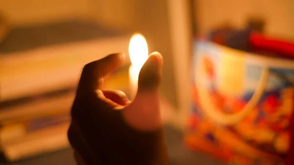 praying hand holding a candle in the mirror