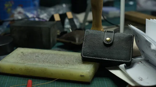 a closeup shot of a handmade leather bag with a knife