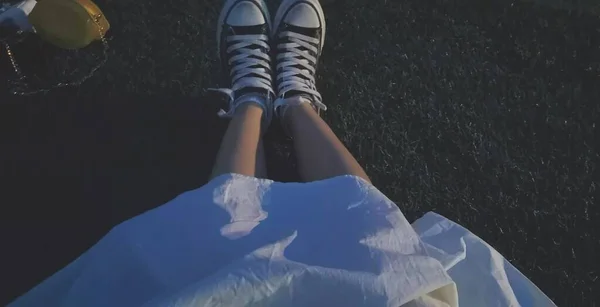 feet of a woman in a black jacket and a white socks on a background of snow