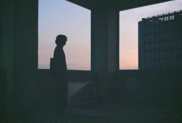 silhouette of a man in a black dress on the roof of the house