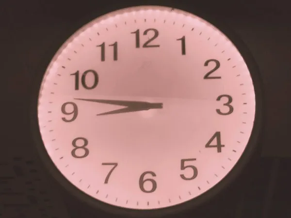 close up of a clock on a black background