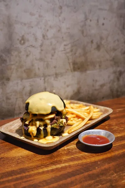 delicious burger with chicken and vegetables on wooden background