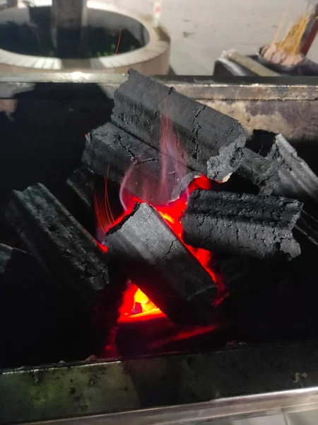 a closeup shot of a burning fire in a metal plate