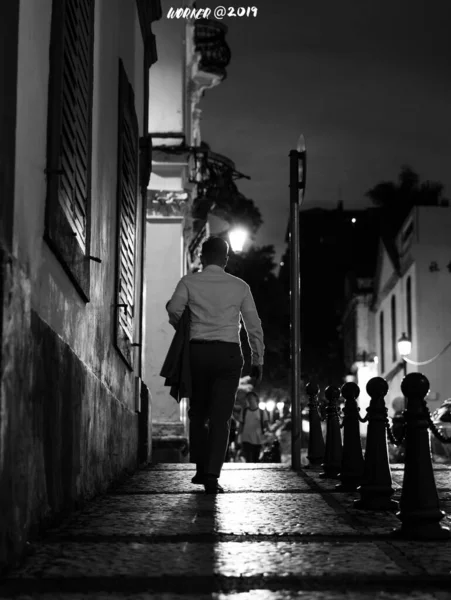 black and white photo of a man and woman walking on the street