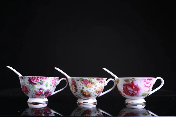 cup of tea and a set of white cups on a black background