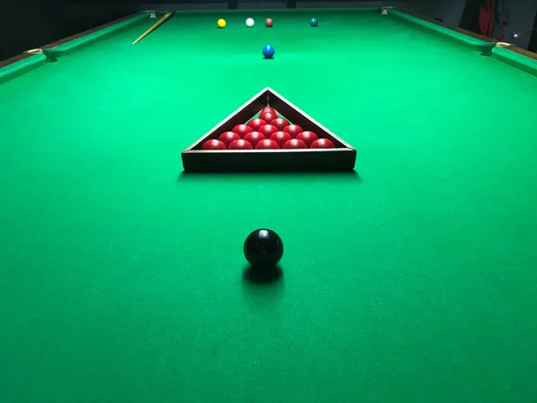 billiard table with cue and pool balls