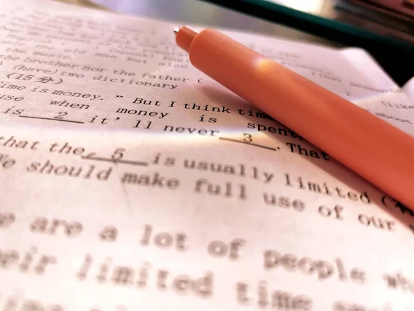 close up of a book with a pen
