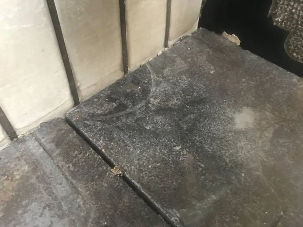 concrete floor with a wall and a puddle