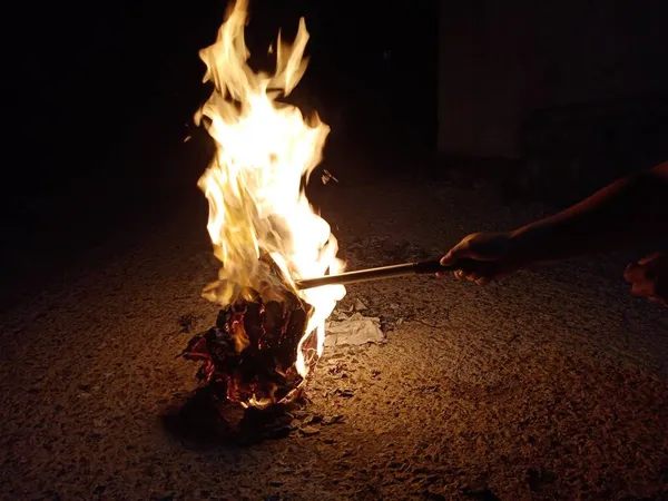 close up of a man\'s hands holding a burning fire