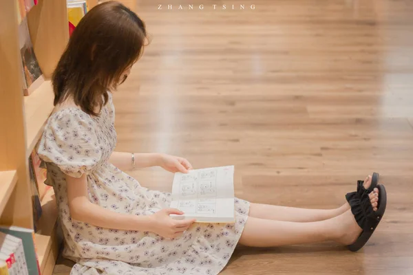 little girl reading a book in the room