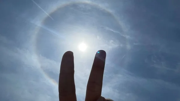 a man's hand holding a star against a blue sky