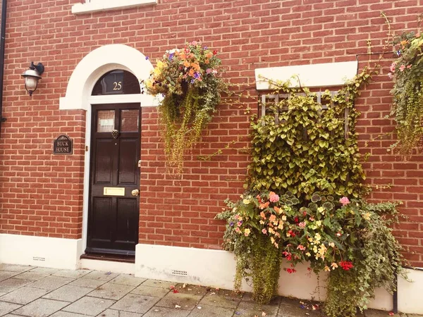 red brick wall with flowers and plants