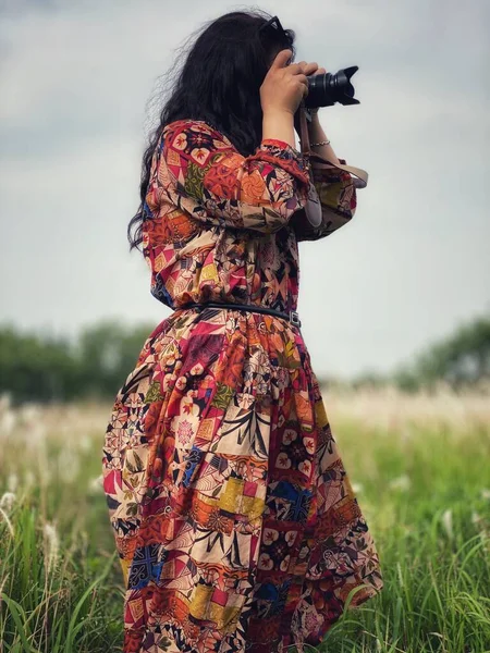 beautiful young woman with a camera in the forest