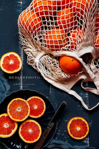 fresh orange and red grapefruit on a wooden background. top view.