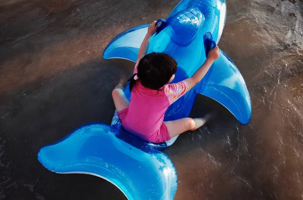 little girl in the pool with a toy