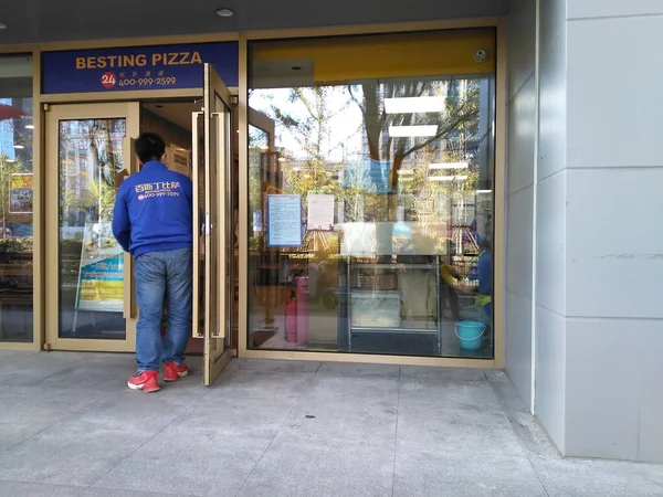 man in a shop with a window