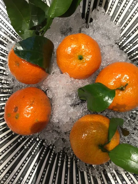 stock image fresh ripe tangerines with leaves on a black background