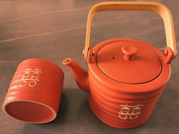 red tea kettle and teapot on a wooden table