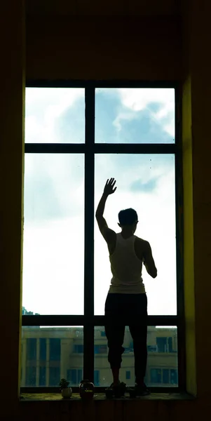 silhouette of a man with a window