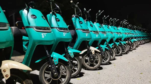 a row of bicycles parked in the parking lot