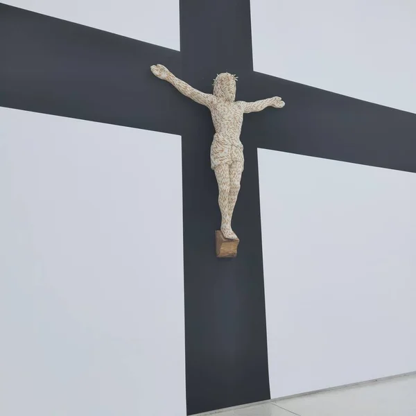 a man in a white dress with a cross on a background of a wall