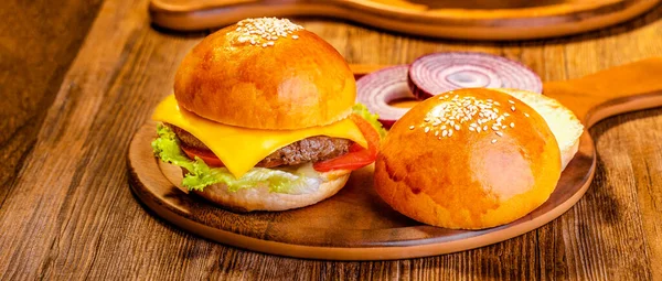 burger with meat and vegetables on wooden background