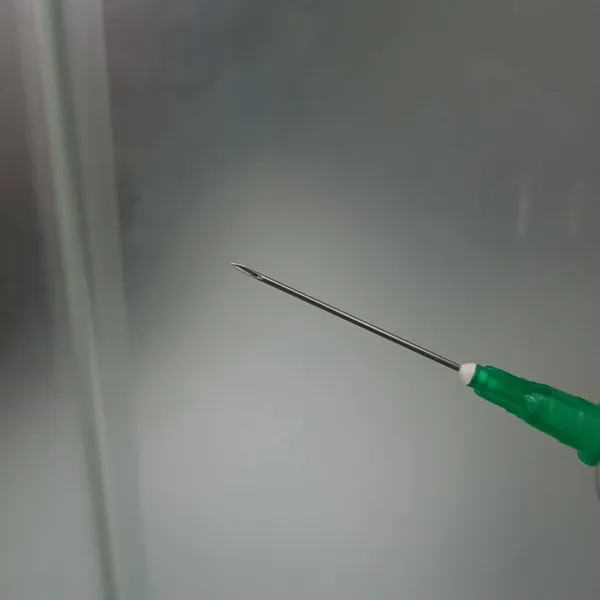 syringe with a needle on a blurred background