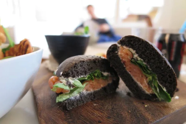 sandwich with meat and vegetables on wooden table