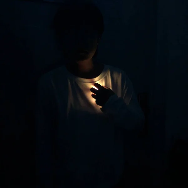 young man with a black hair in a dark room