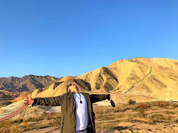 a man in a red jacket and a backpack on a mountain top