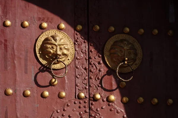 golden door with a red handle