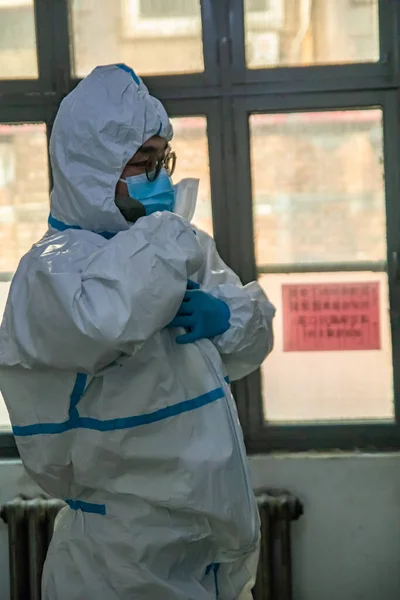 a man in a protective mask and gloves is working in a hospital.