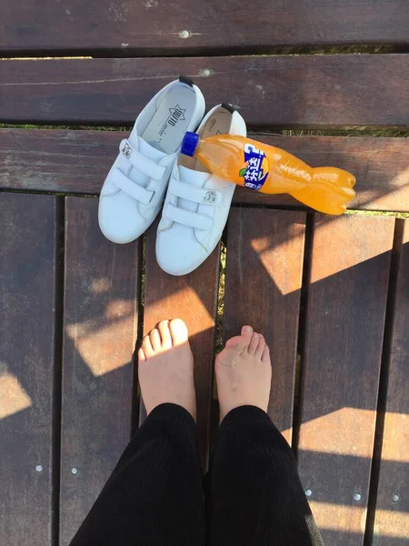 female feet in sandals on wooden floor