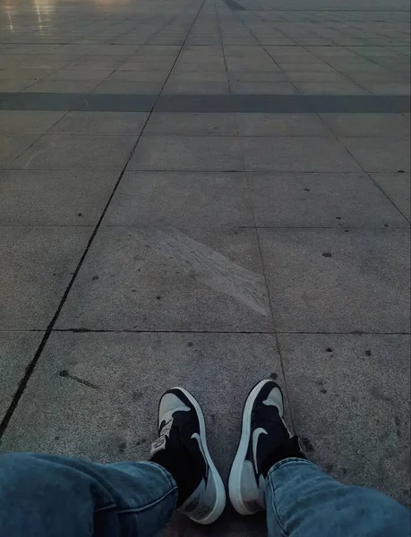 feet of a man sitting on the floor and looking at the distance