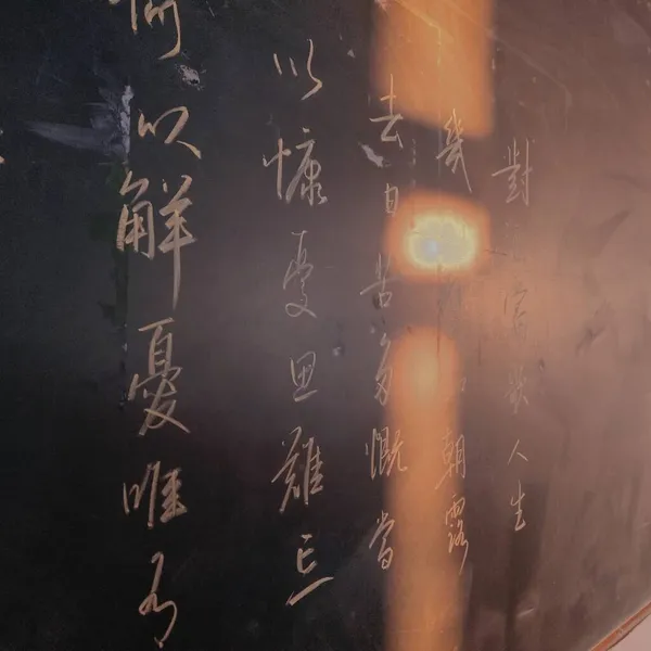 close up of a hand writing on a blackboard