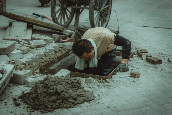 worker in a protective mask works on the floor of the building