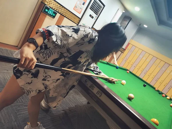 woman playing billiards with ball and cue