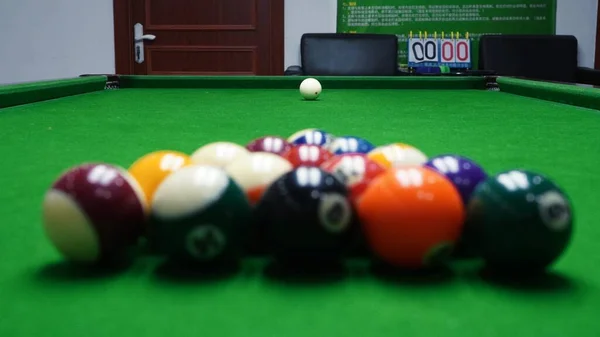 billiard table with cue and pool balls