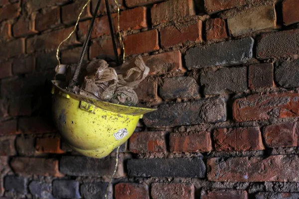 old rusty metal pot on a brick wall