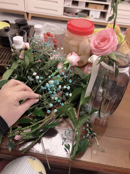 florist making bouquet of roses in a shop