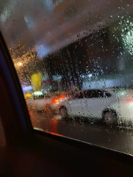 car window with rain drops on the windshield